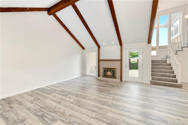 9738 Nieman Pl, Overland Park, KS 66214 - unfurnished living room featuring stairs, a brick fireplace, wood finished floors, baseboards, and lofted ceiling with beams