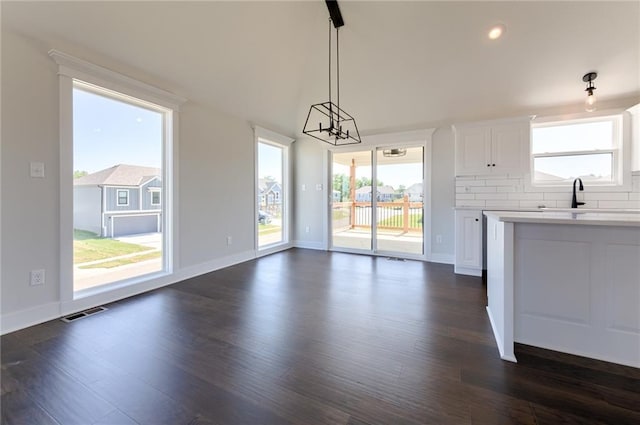 1308 N Holland Dr, Independence, MO 64056 - unfurnished dining area with dark wood-style flooring, baseboards, a sink, lofted ceiling, and recessed lighting