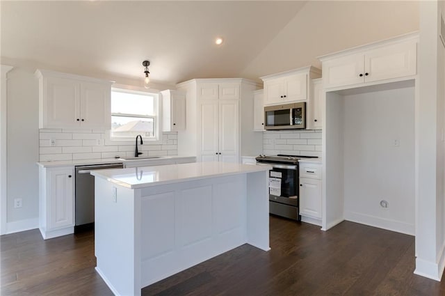 1308 N Holland Dr, Independence, MO 64056 - kitchen with stainless steel appliances, a sink, white cabinets, backsplash, and lofted ceiling