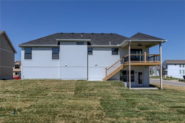 1308 N Holland Dr, Independence, MO 64056 - rear view of house featuring a ceiling fan, a yard, stairs, and roof with shingles