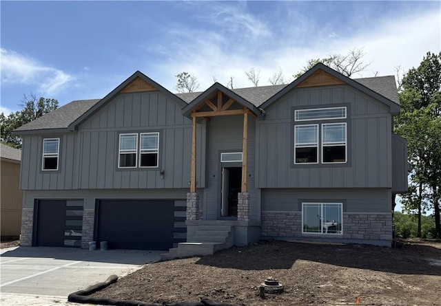 1308 N Holland Dr, Independence, MO 64056 - view of front of property featuring stone siding, a garage, concrete driveway, and board and batten siding