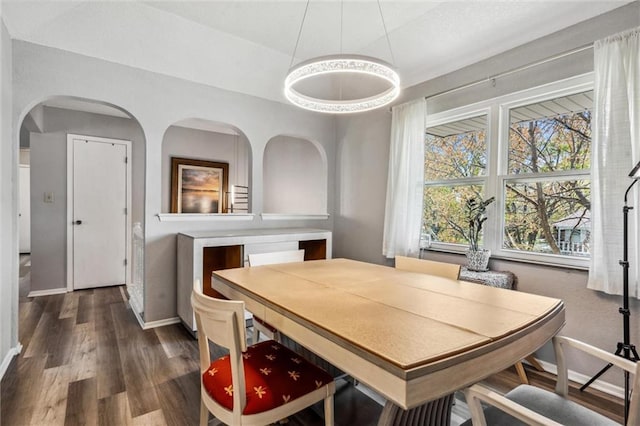 5101 NW Downing St, Blue Springs, MO 64015 - dining space featuring wood finished floors, baseboards, and arched walkways
