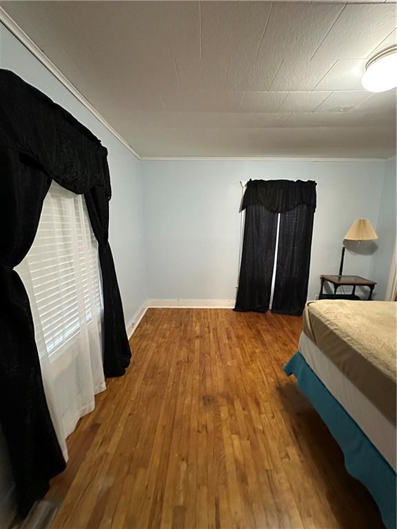 bedroom featuring wood-type flooring and baseboards