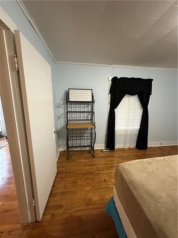 bedroom featuring wood finished floors and baseboards