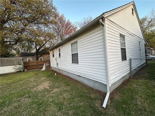 view of property exterior with crawl space, a yard, and fence