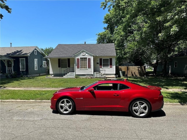 bungalow with crawl space, roof with shingles, fence, and a front lawn