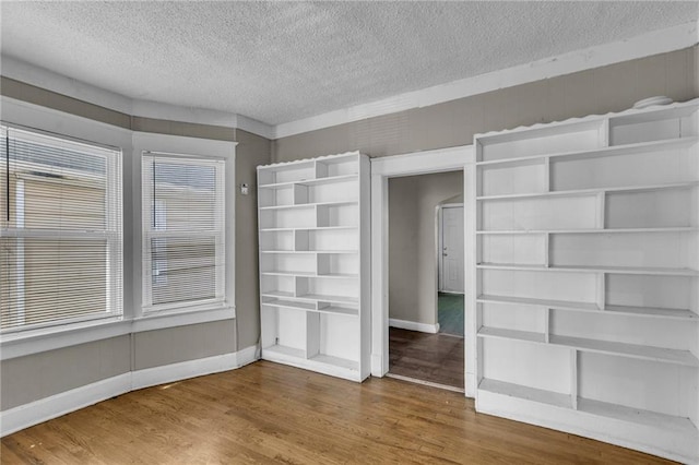 442 N Colorado Ave, Kansas City, MO 64123 - unfurnished bedroom featuring baseboards, wood finished floors, and a textured ceiling