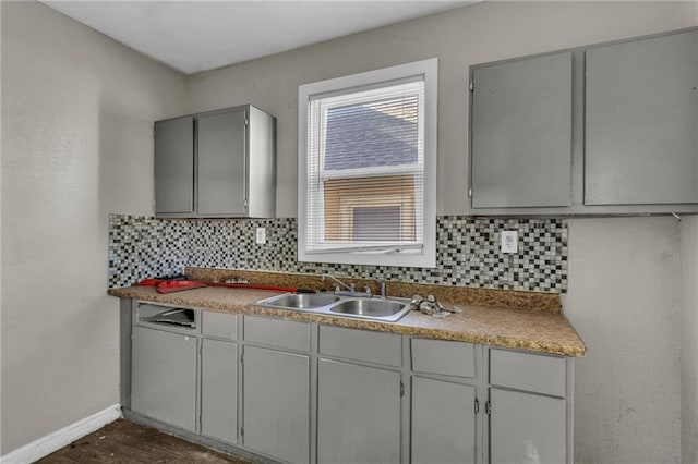 442 N Colorado Ave, Kansas City, MO 64123 - kitchen featuring gray cabinets, baseboards, tasteful backsplash, and a sink