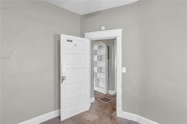 442 N Colorado Ave, Kansas City, MO 64123 - unfurnished room featuring arched walkways, carpet flooring, and baseboards
