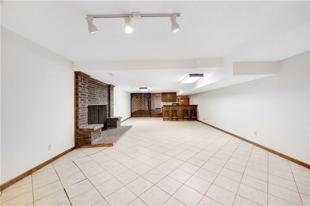 1707 NW Ashton Dr, Blue Springs, MO 64015 - unfurnished living room with bar, light tile patterned floors, baseboards, and a brick fireplace