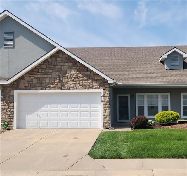 1219 S 3rd St, Louisburg, KS 66053 - view of front facade with stone siding, driveway, roof with shingles, a garage, and a front yard