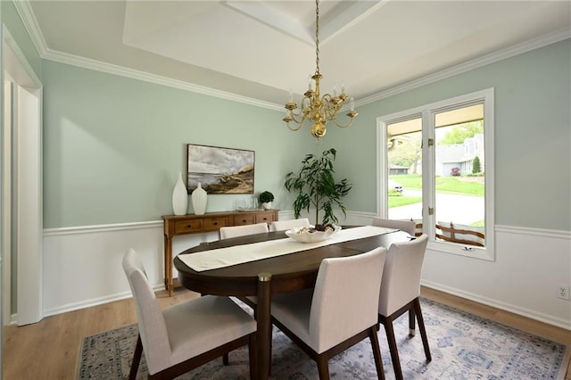 dining area with an inviting chandelier, baseboards, ornamental molding, and light wood finished floors