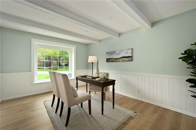 office area featuring beam ceiling, wainscoting, and wood finished floors