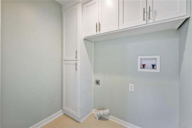 clothes washing area featuring baseboards, hookup for an electric dryer, hookup for a washing machine, and cabinet space