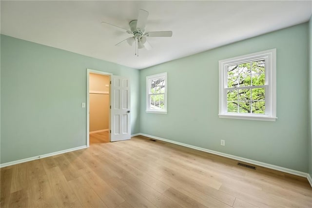 spare room with baseboards, a wealth of natural light, and visible vents