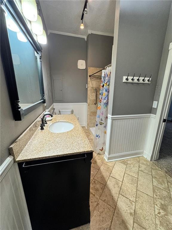 bathroom featuring wainscoting, crown molding, and curtained shower