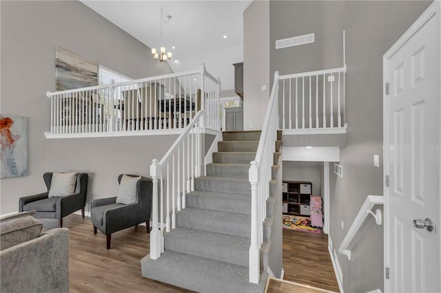 16754 W 156th Ter, Olathe, KS 66062 - stairs featuring a towering ceiling, wood finished floors, a chandelier, baseboards, and recessed lighting