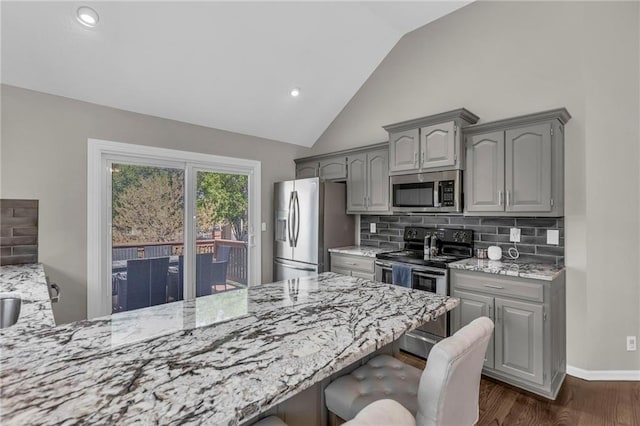 16754 W 156th Ter, Olathe, KS 66062 - kitchen featuring appliances with stainless steel finishes, gray cabinets, a kitchen breakfast bar, vaulted ceiling, and backsplash