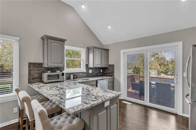 16754 W 156th Ter, Olathe, KS 66062 - kitchen with stainless steel appliances, gray cabinets, a peninsula, a kitchen bar, and a sink
