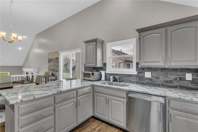 16754 W 156th Ter, Olathe, KS 66062 - kitchen with stainless steel dishwasher, lofted ceiling, gray cabinetry, a sink, and a peninsula