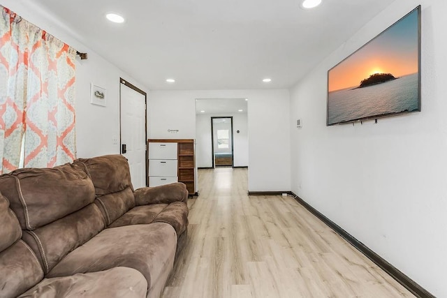 living area with baseboards, recessed lighting, and light wood-style flooring