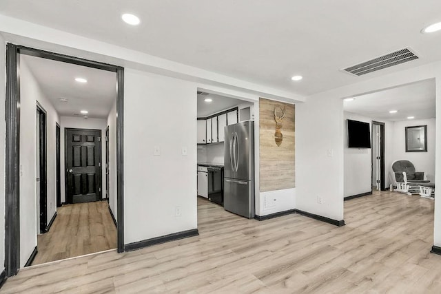 interior space with freestanding refrigerator, dishwasher, visible vents, and light wood-style floors