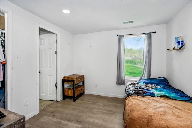 bedroom featuring baseboards, wood finished floors, visible vents, and recessed lighting