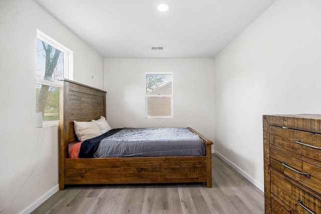 bedroom featuring baseboards, wood finished floors, visible vents, and recessed lighting