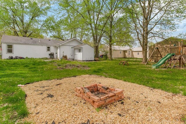 view of yard with an outdoor fire pit and a playground