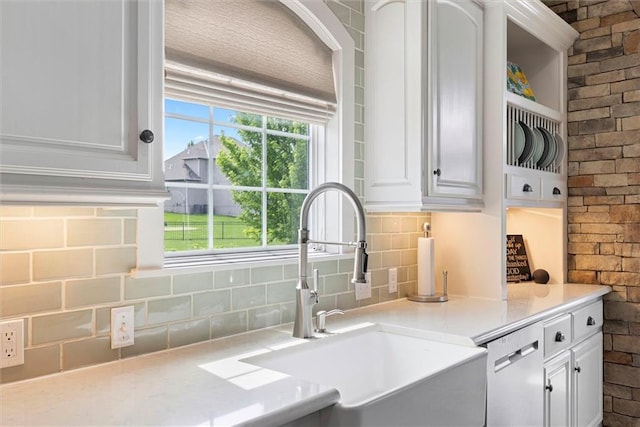 24212 W 69th St, Shawnee, KS 66226 - kitchen with a sink, stainless steel dishwasher, white cabinetry, backsplash, and light countertops
