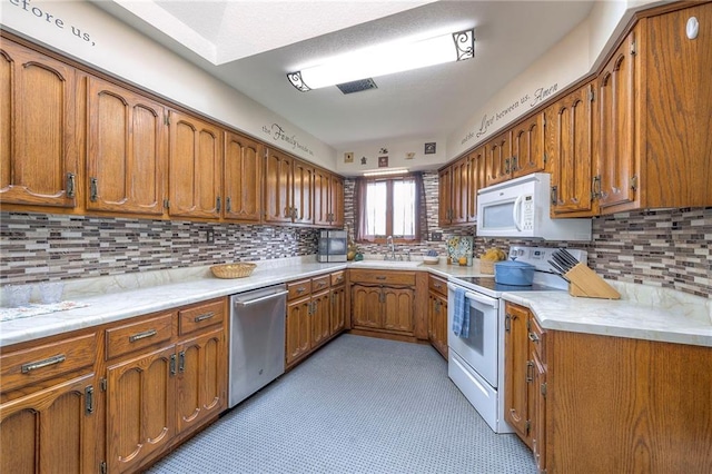 24101 E 223rd St, Harrisonville, MO 64701 - kitchen featuring a sink, brown cabinets, white appliances, and light countertops