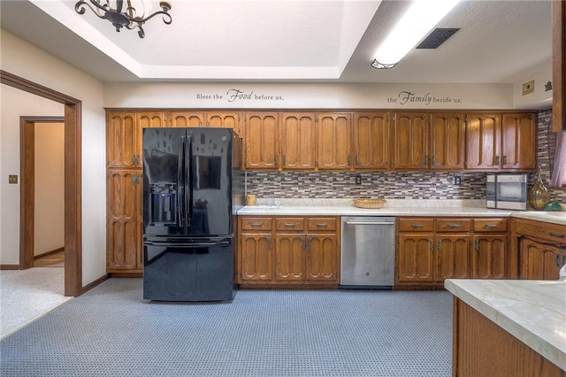 24101 E 223rd St, Harrisonville, MO 64701 - kitchen with decorative backsplash, black fridge with ice dispenser, brown cabinets, dishwasher, and light countertops