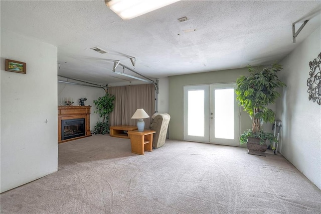 24101 E 223rd St, Harrisonville, MO 64701 - carpeted living area with a fireplace, french doors, a textured ceiling, and visible vents