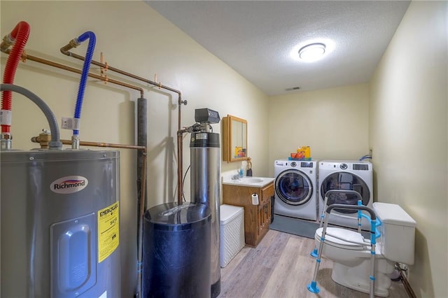 24101 E 223rd St, Harrisonville, MO 64701 - washroom featuring laundry area, a textured ceiling, light wood finished floors, water heater, and washer and dryer