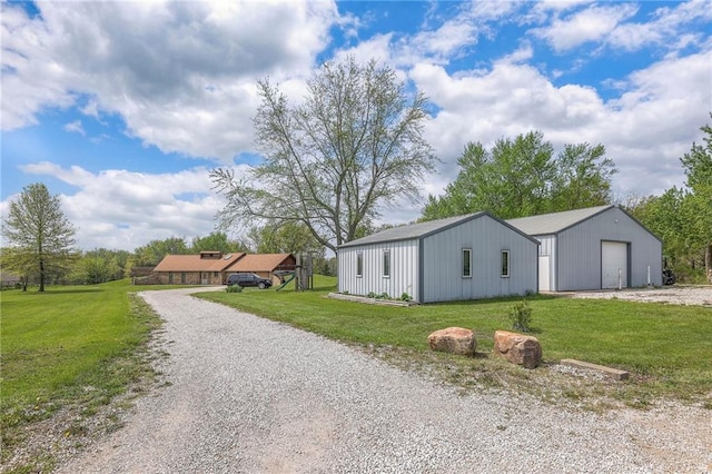 24101 E 223rd St, Harrisonville, MO 64701 - view of front of home with an outdoor structure, a front lawn, driveway, an outbuilding, and a detached garage