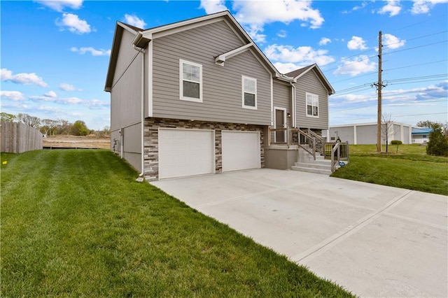 view of front of property featuring stone siding, concrete driveway, a front yard, and a garage