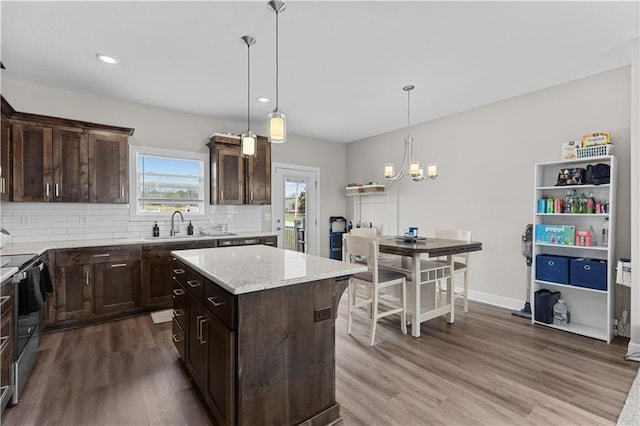 kitchen featuring dark brown cabinets, range with electric stovetop, wood finished floors, and tasteful backsplash