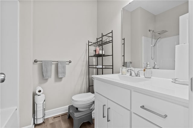 bathroom with toilet, baseboards, visible vents, walk in shower, and wood finished floors