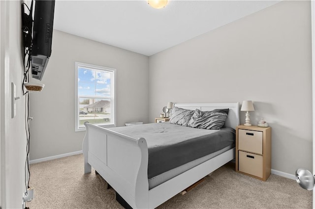 bedroom with light carpet and baseboards