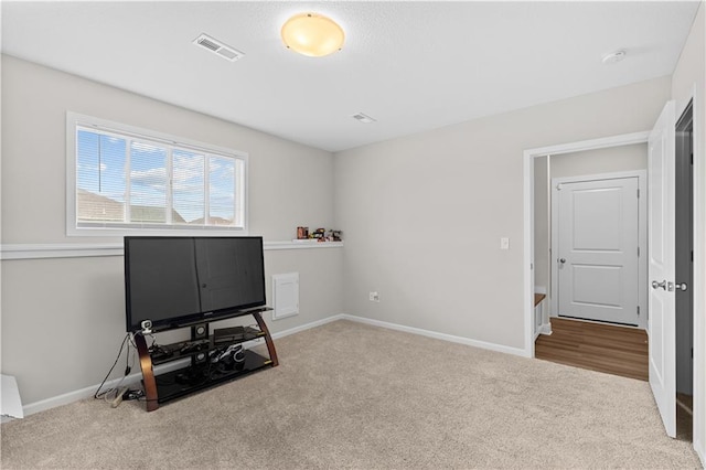 interior space featuring baseboards, visible vents, and carpet