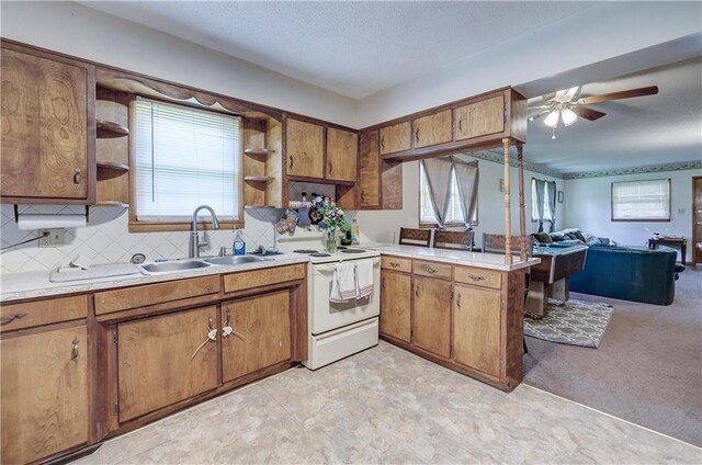 kitchen featuring a sink, open floor plan, brown cabinets, open shelves, and white range with electric stovetop