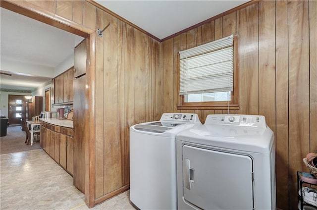 laundry area featuring wood walls and independent washer and dryer
