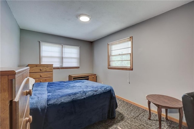carpeted bedroom with baseboards and a textured ceiling