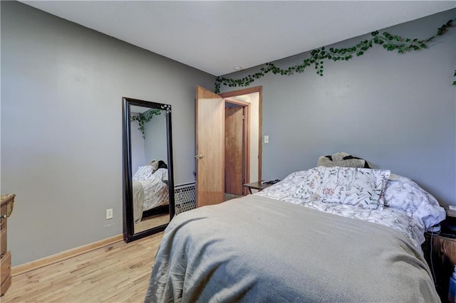 bedroom featuring light wood finished floors and baseboards