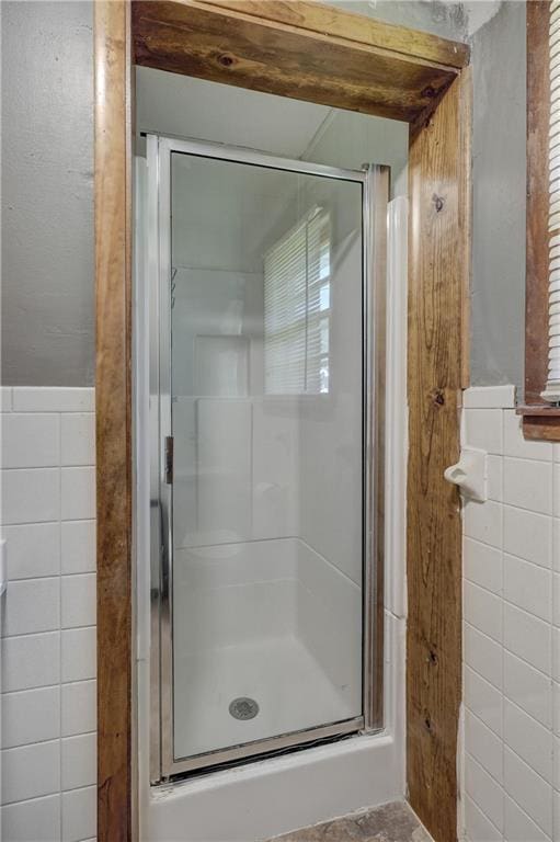 bathroom featuring a stall shower and tile walls