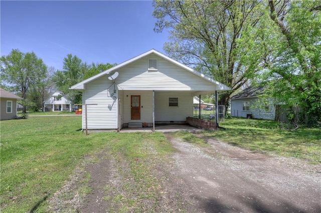 bungalow-style house with dirt driveway, crawl space, a front yard, and an attached carport