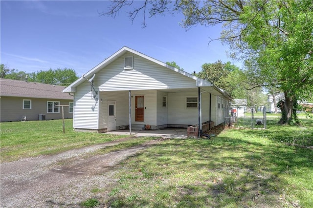 bungalow-style home featuring central air condition unit, a front yard, and a carport