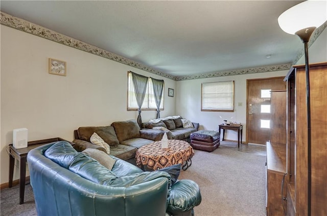 carpeted living room featuring baseboards and a healthy amount of sunlight
