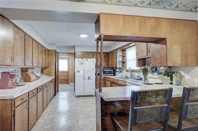 kitchen with open shelves, a sink, decorative backsplash, white fridge with ice dispenser, and stainless steel microwave