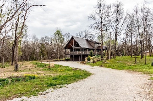 185 SW 51st Rd, Warrensburg, MO 64093 - rustic home with gravel driveway, a wooden deck, and metal roof